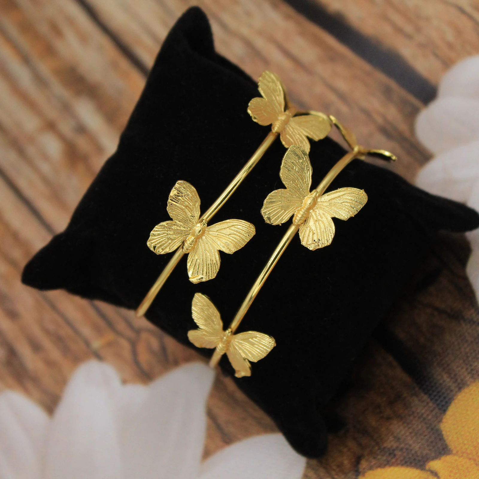 Gold bangles laid on a black velvet cushion