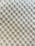 A textured surface with a repetitive pattern of raised circular bumps, resembling a bubble wrap or embossed material. The lighting casts subtle shadows, highlighting the three-dimensional quality of the texture.