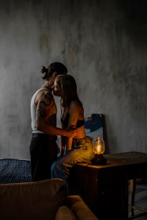 Soft-lit lounge corner where a couple shares a quiet, genuine conversation.