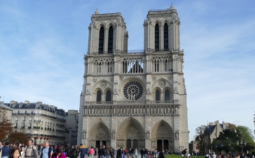 a group of people standing in front of a large cathedral