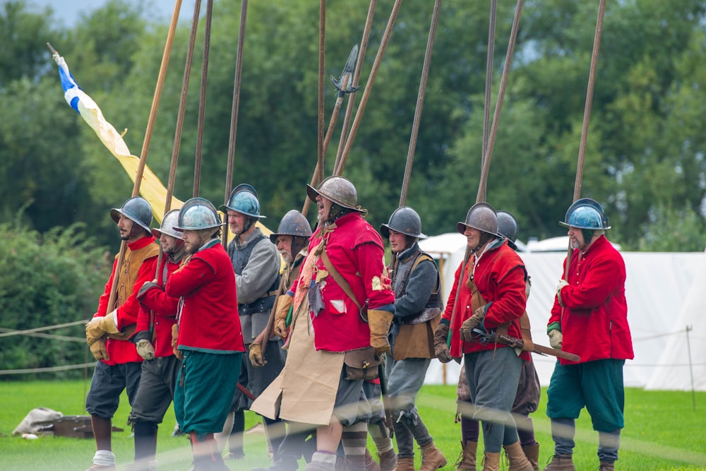 a group of men in red coats and helmets standing next to each other