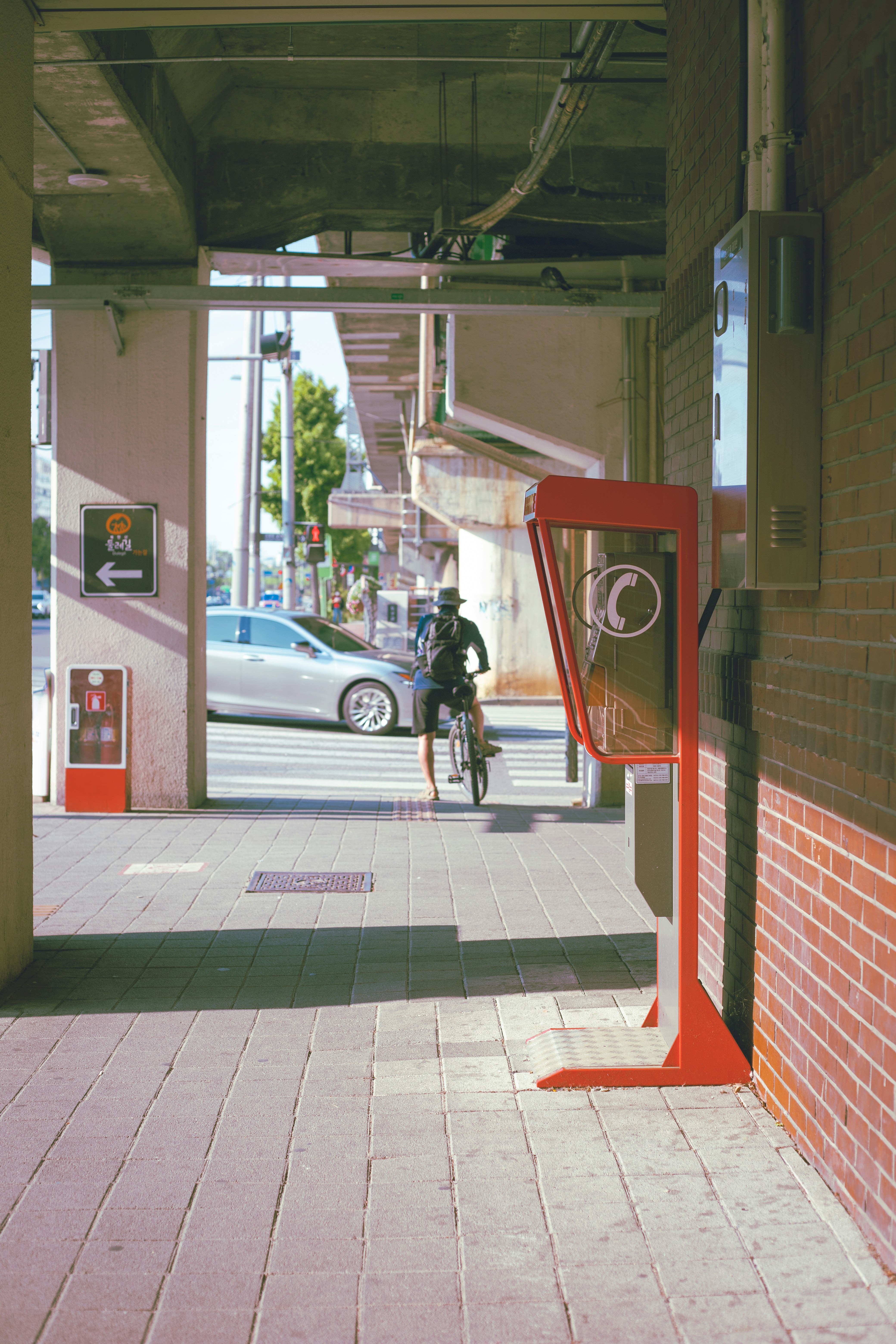 a man riding a bike down a sidewalk next to a parking meter