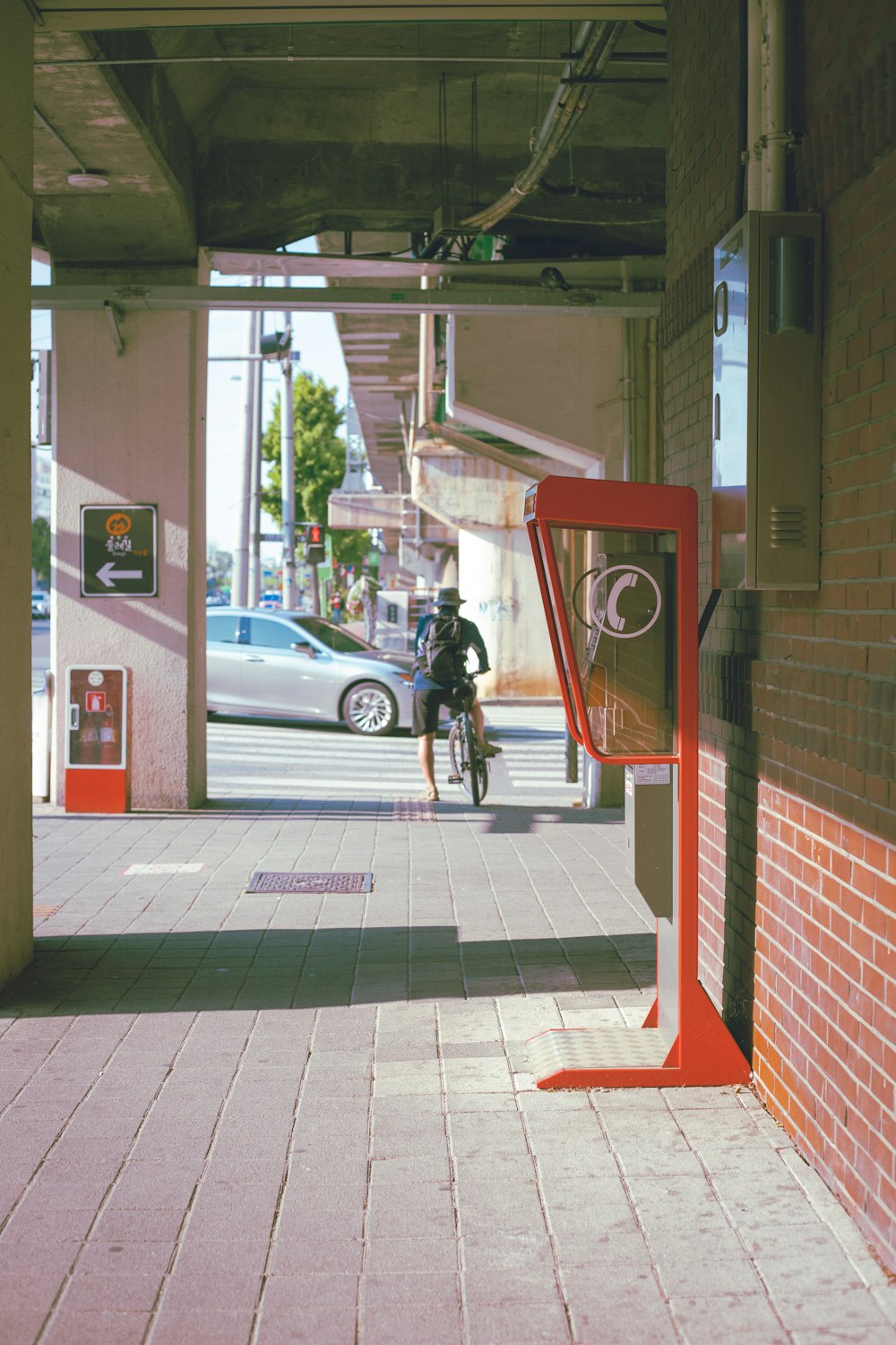 a man riding a bike down a sidewalk next to a parking meter