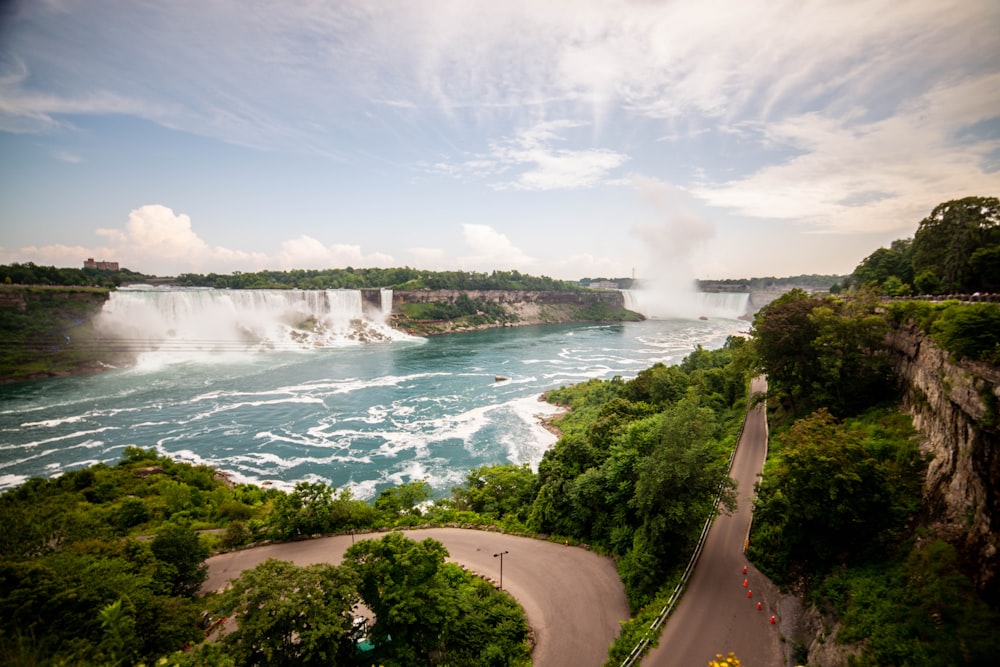 a scenic view of a waterfall and a road