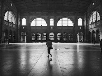 a black and white photo of a person in a train station