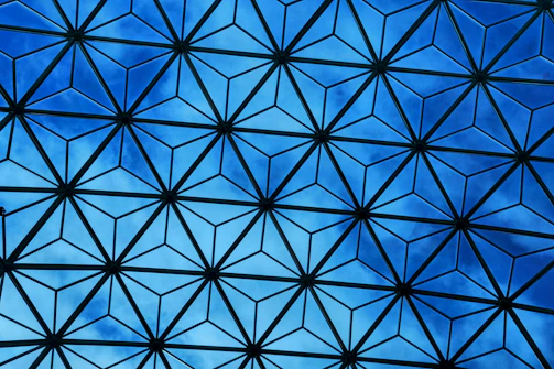 A sleek silver hexagonal pattern overlaying a deep ocean blue background, symbolizing connection and trust.