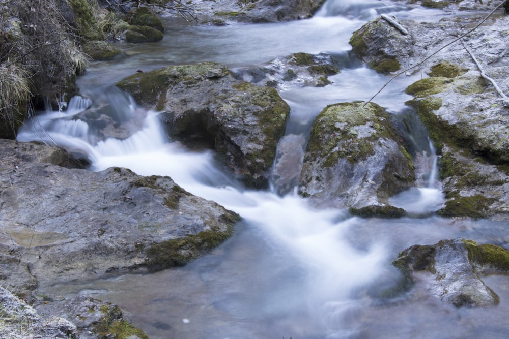 a stream of water running over rocks in a forest