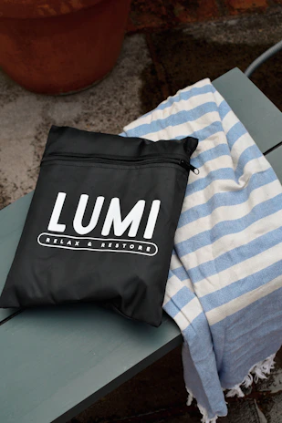 Close-up of an élansac travel bag resting on a wooden bench with soft morning light.