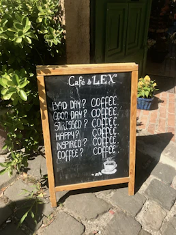 A colorful chalkboard sign outside stir d' cup featuring daily coffee specials and tempting food offers.
