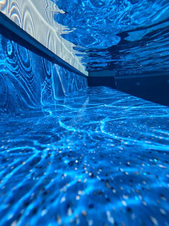 Underwater shot of a pool with installed blue LED lights glowing softly.