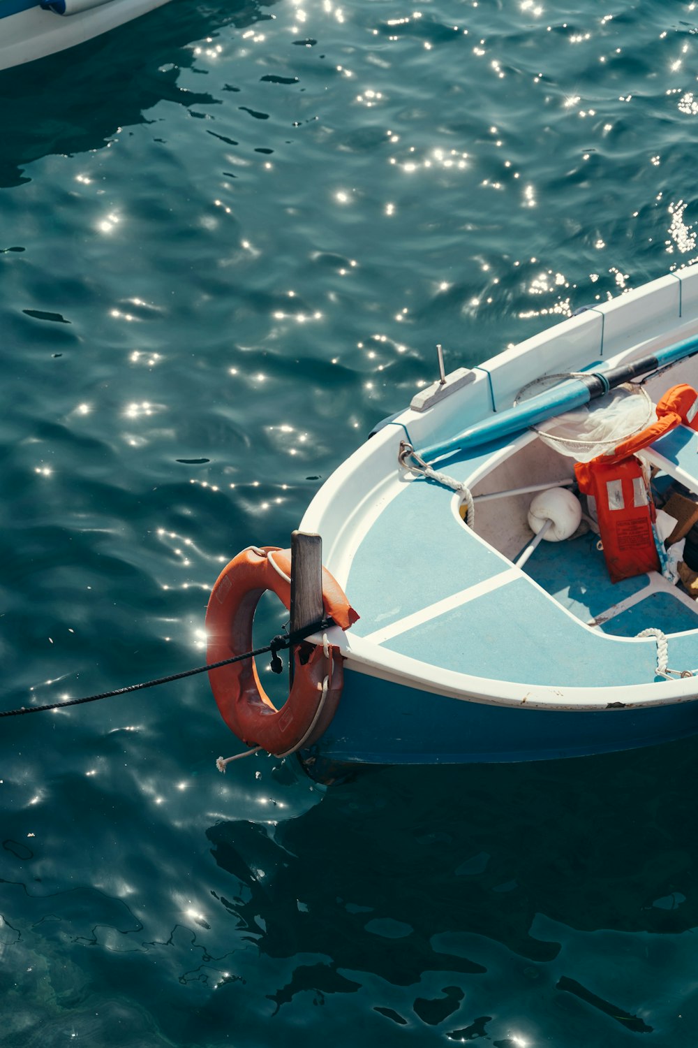 a small blue boat floating on top of a body of water