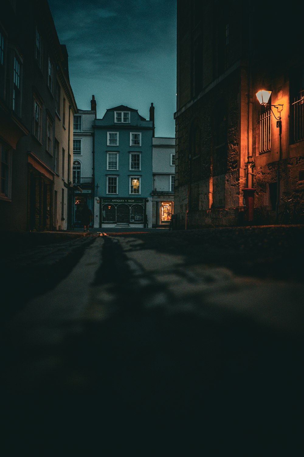 a dark street at night with a building in the background