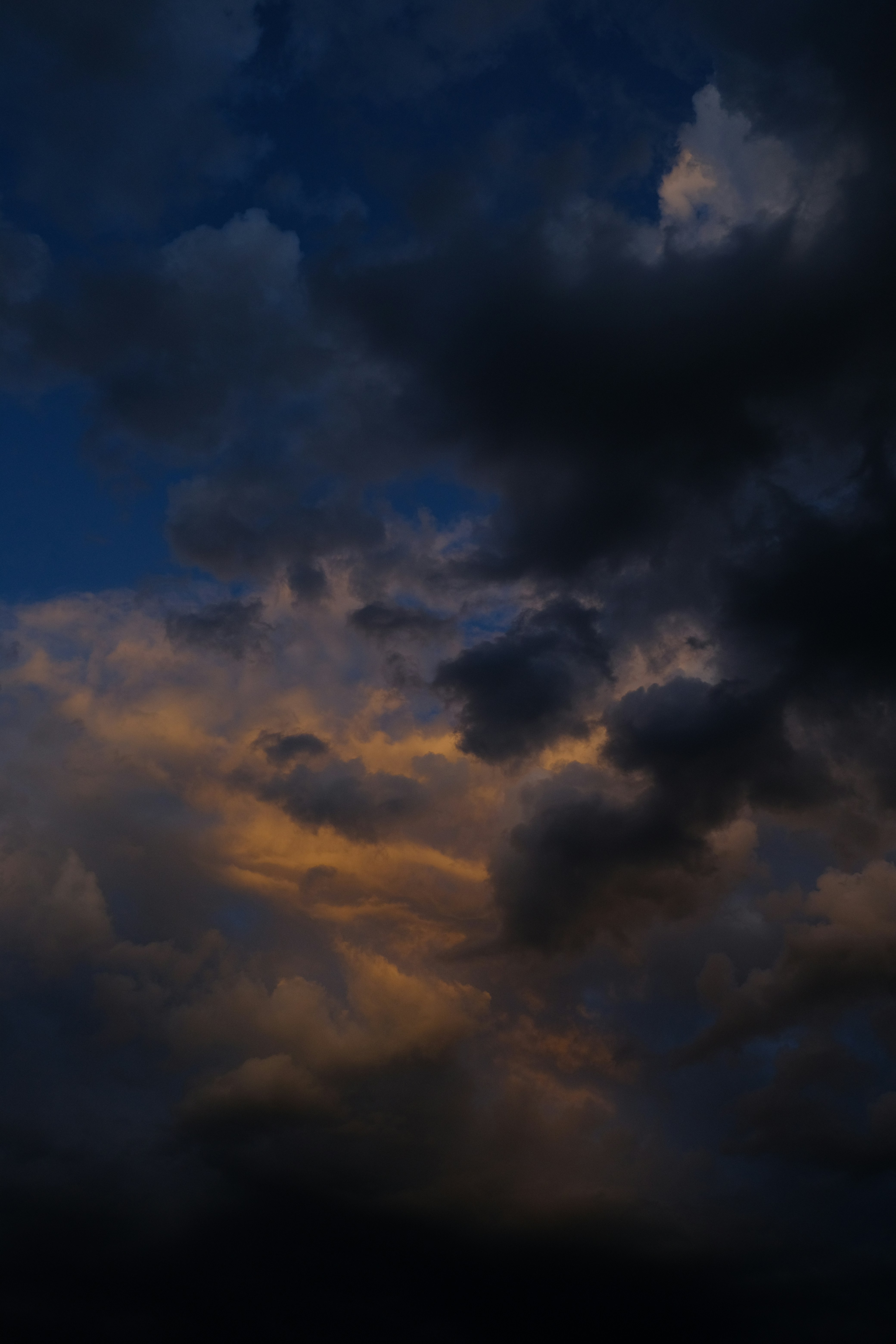 a plane flying through a cloudy sky at night