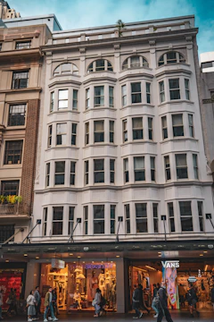 A renovated commercial property with storefronts and people walking by.