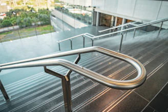 Close-up of a handcrafted metal staircase with sleek green accents in an industrial setting.
