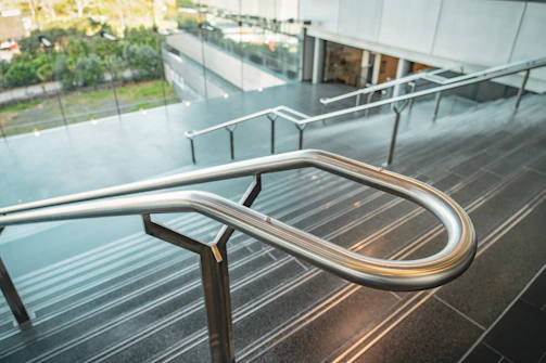 Close-up of a handcrafted metal staircase with sleek green accents in an industrial setting.