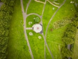 an aerial view of a park with a red and white umbrella