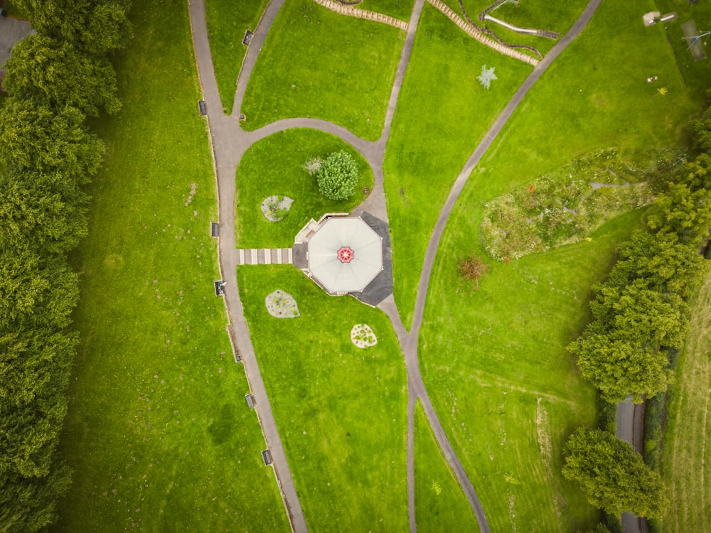 an aerial view of a park with a red and white umbrella