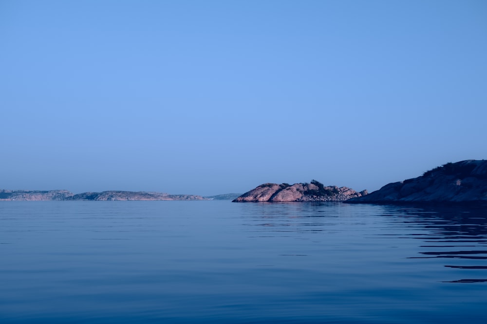 ein Gewässer mit einer kleinen Insel in der Ferne