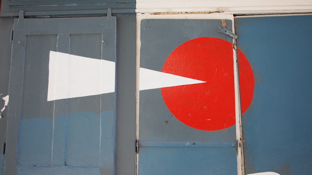 a red and white arrow painted on the side of a building