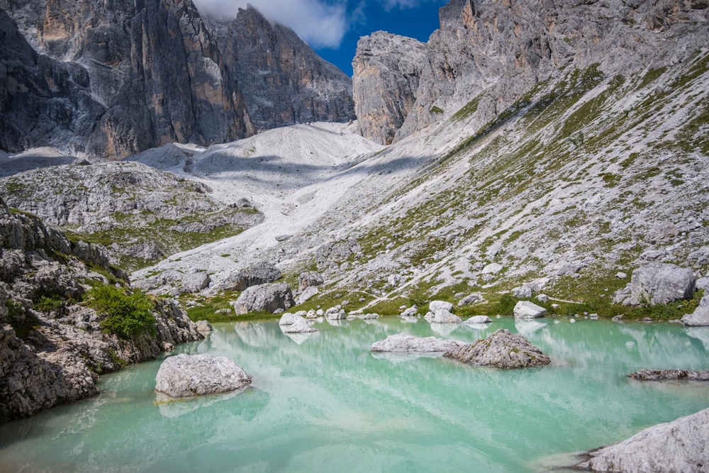 a mountain lake surrounded by rocks and green water