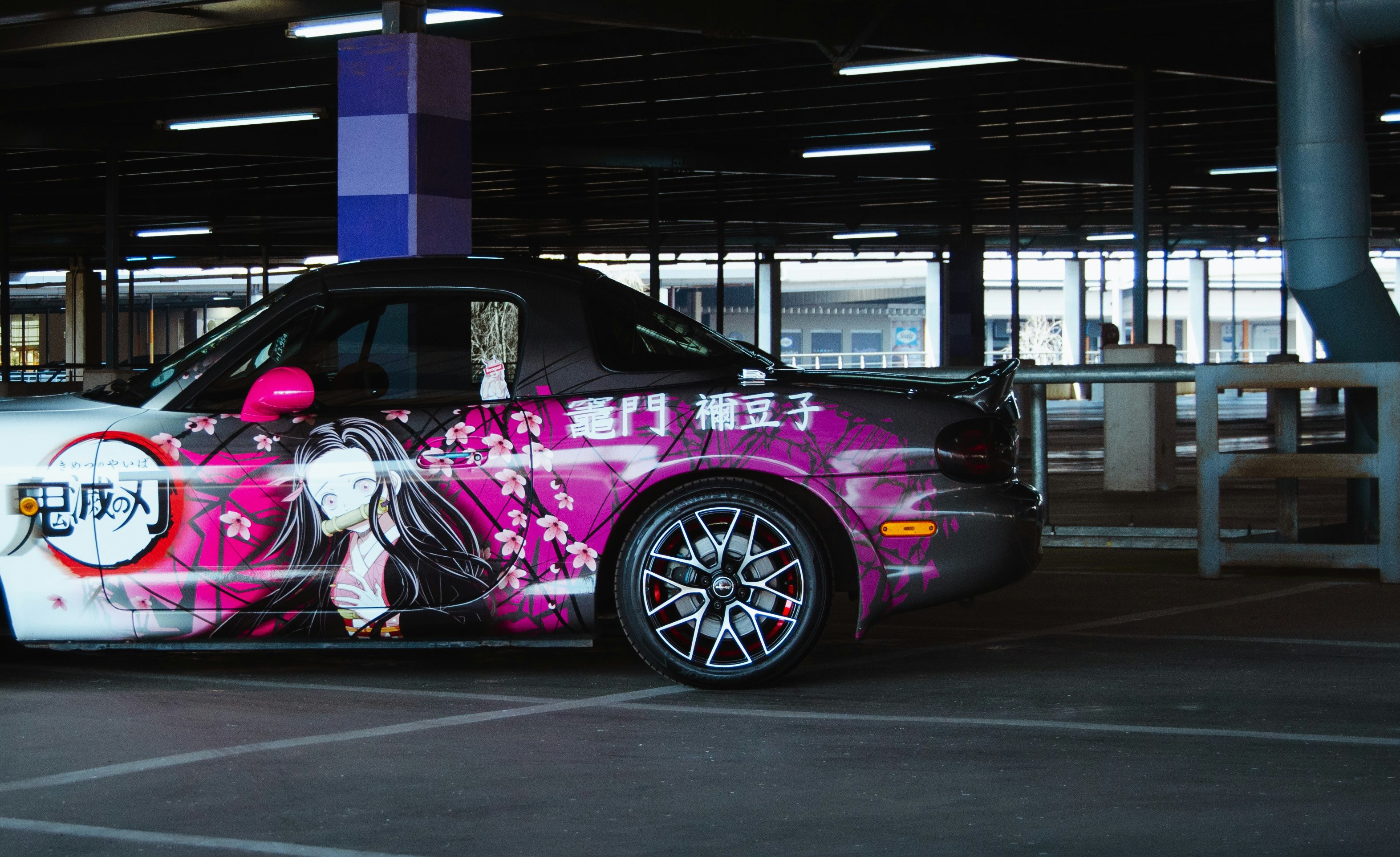 Technician inspecting vehicle body condition and factory paint before wrap installation