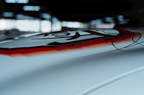 Close-up of a sleek industrial design piece featuring sharp crimson lines against a deep black background.