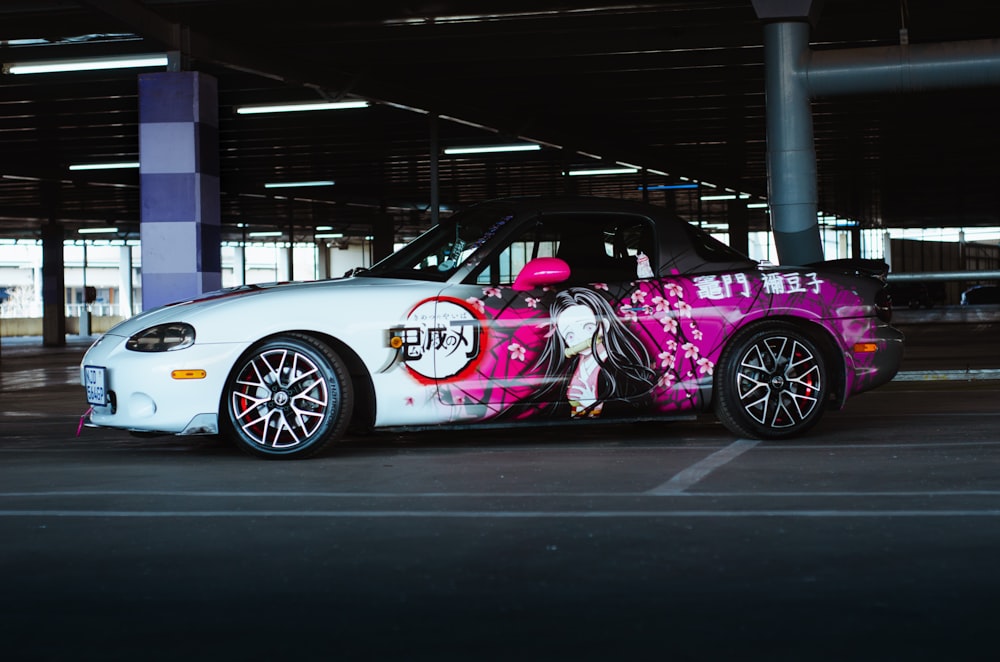 a pink and white car parked in a parking lot