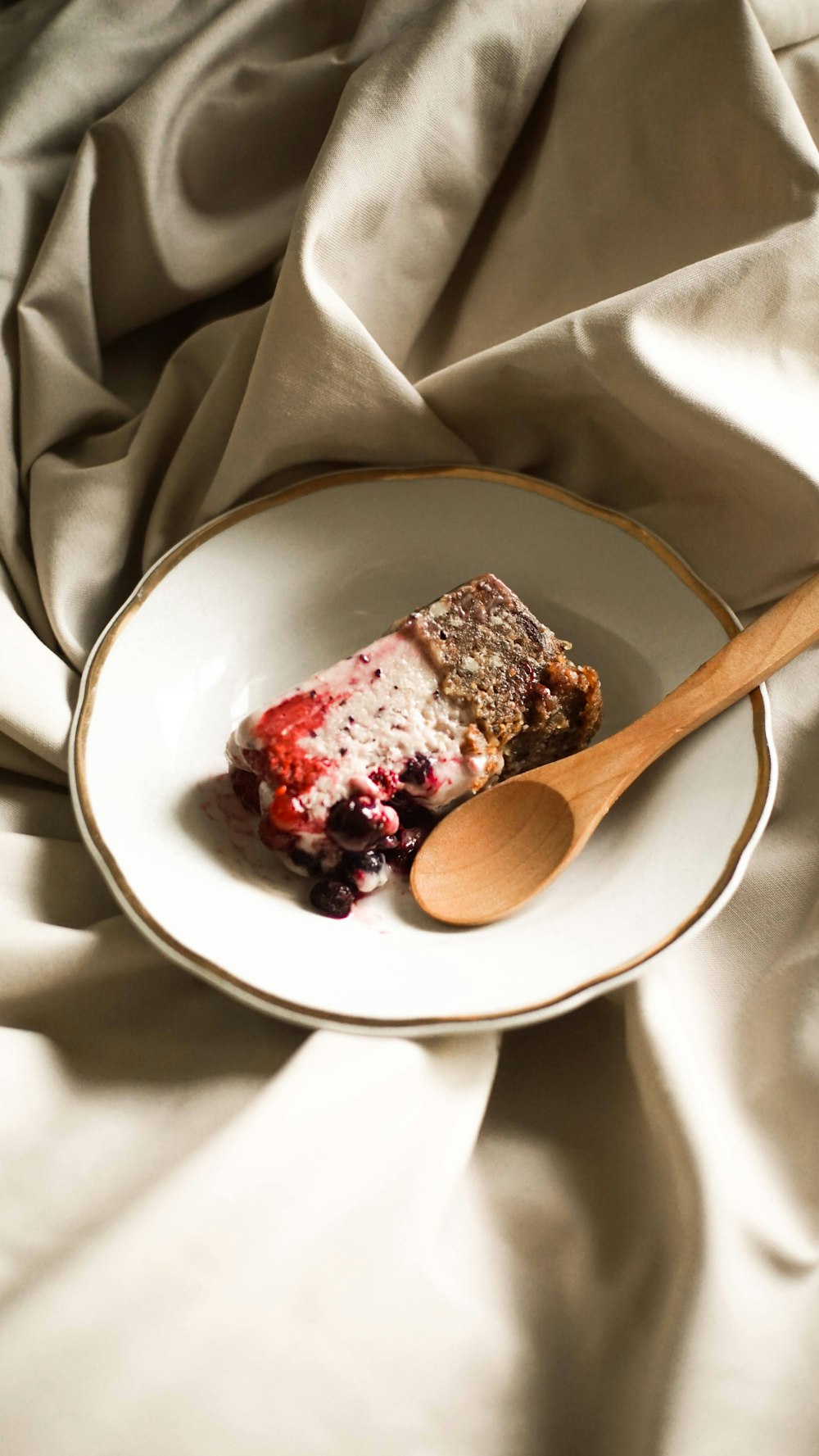 a piece of cake on a plate with a wooden spoon