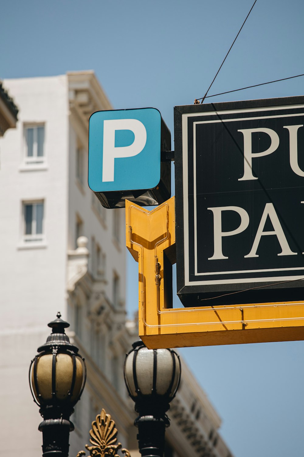 a public pay sign hanging off the side of a building