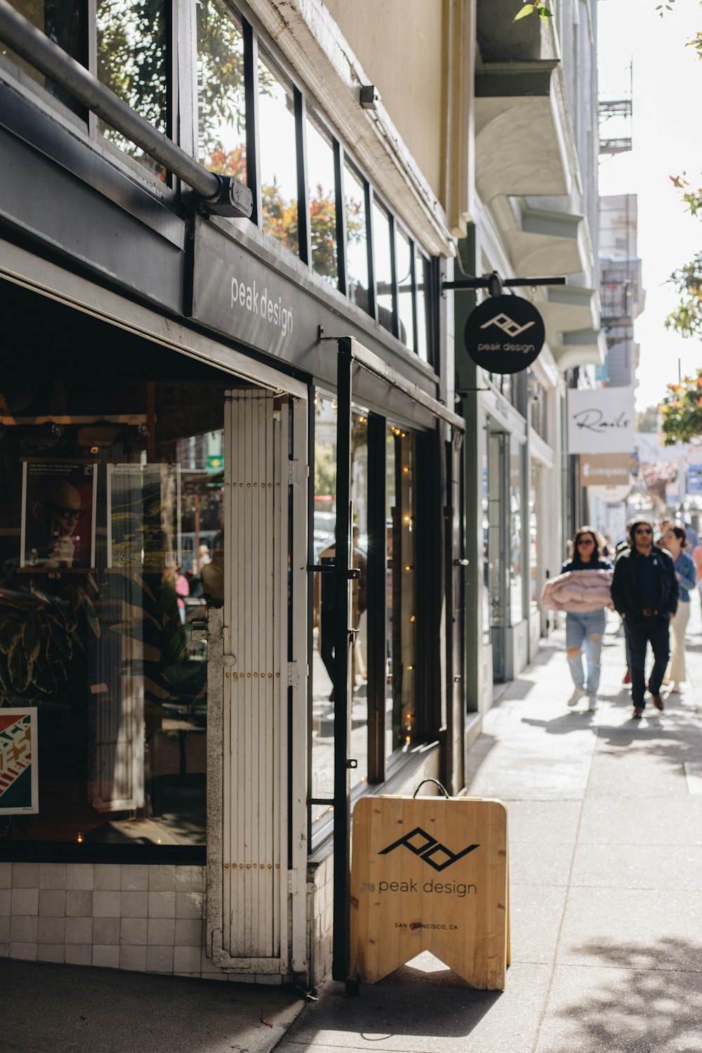 people walking down a sidewalk in front of a store