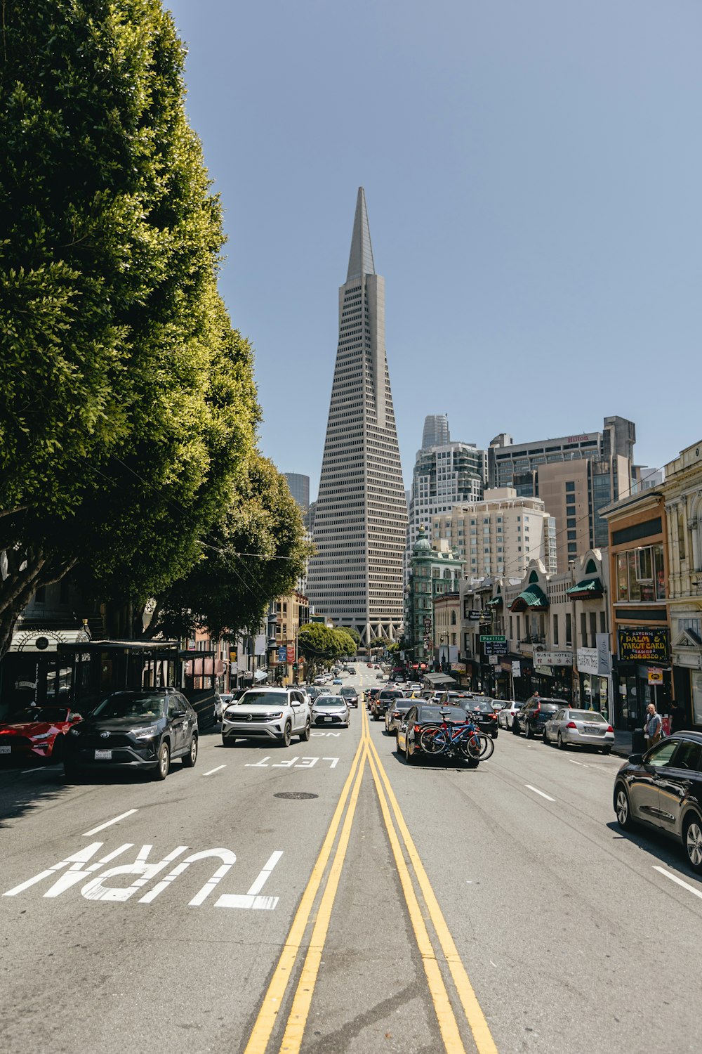 a city street lined with tall buildings and parked cars