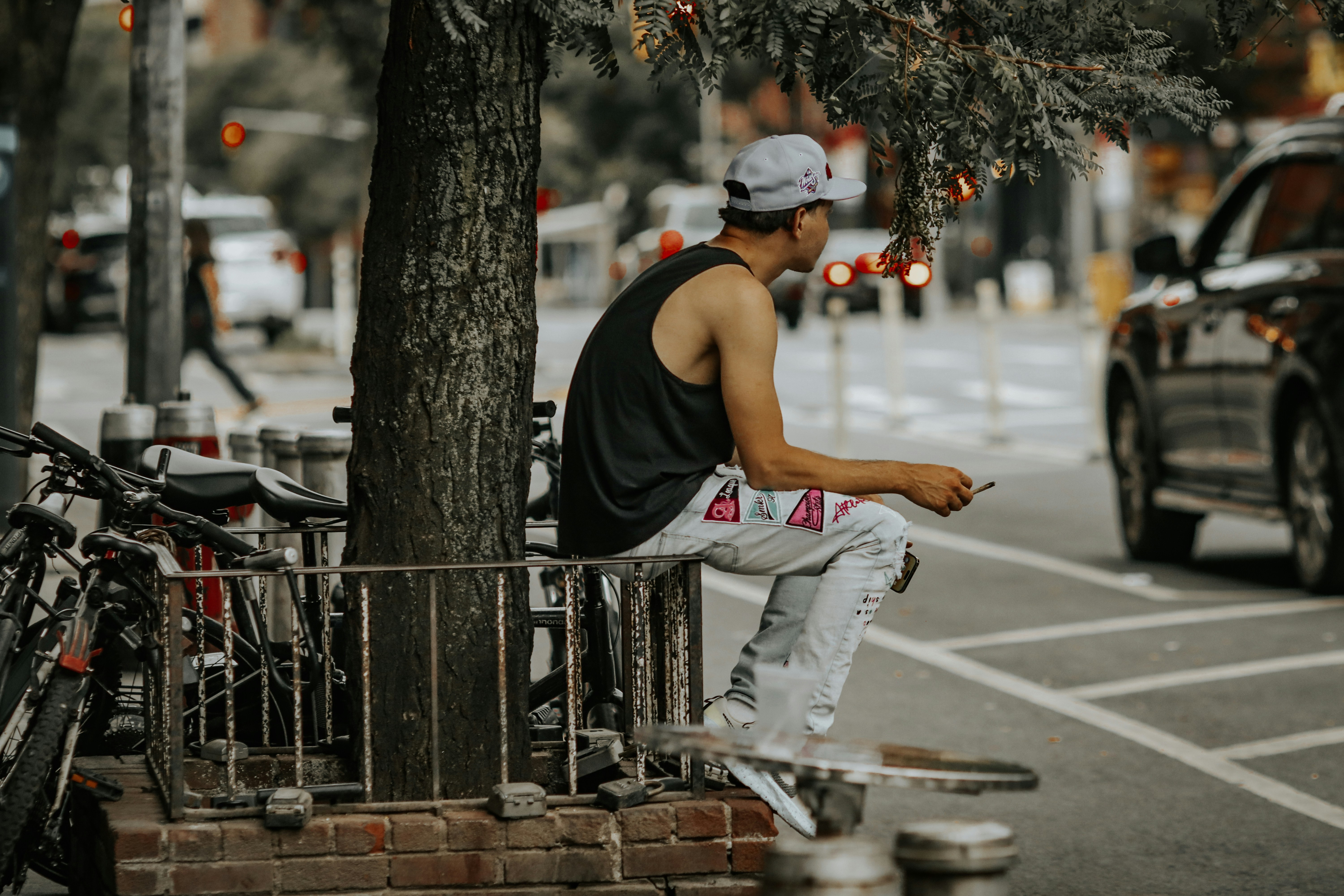 a man sitting on a bench next to a tree