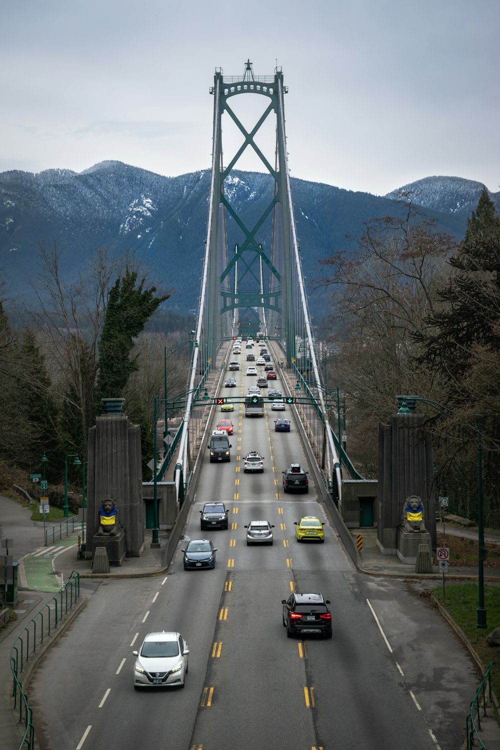 a bridge with cars going over it and mountains in the background