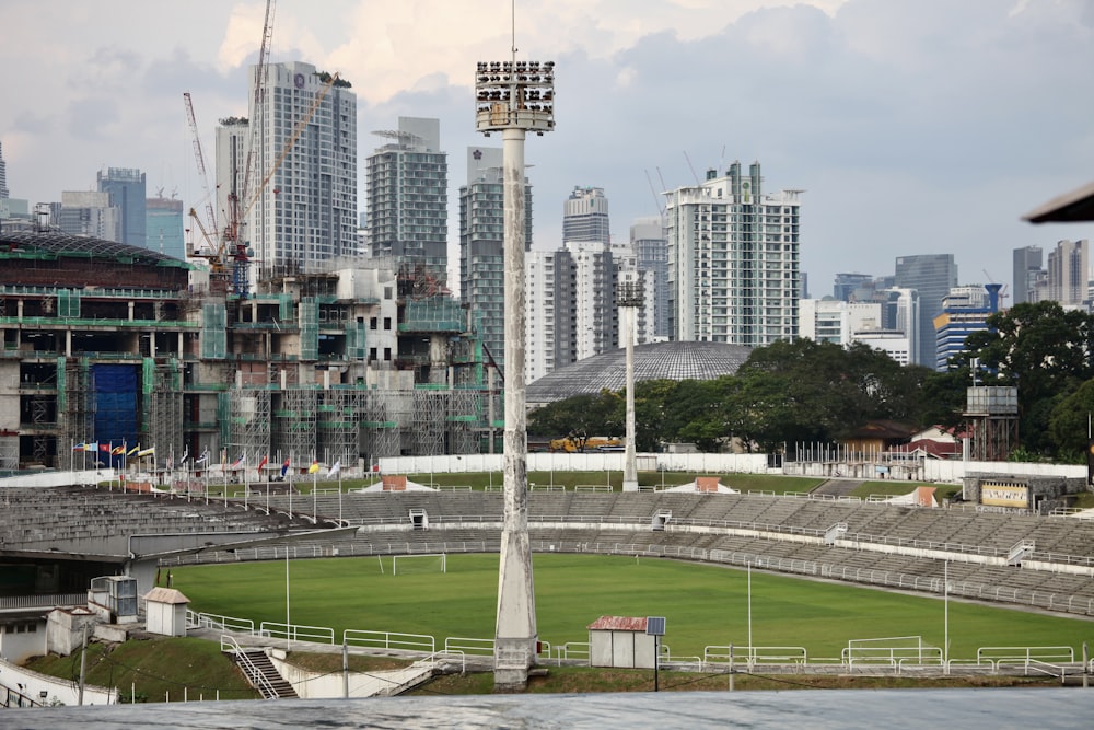 a stadium with a field in front of a city