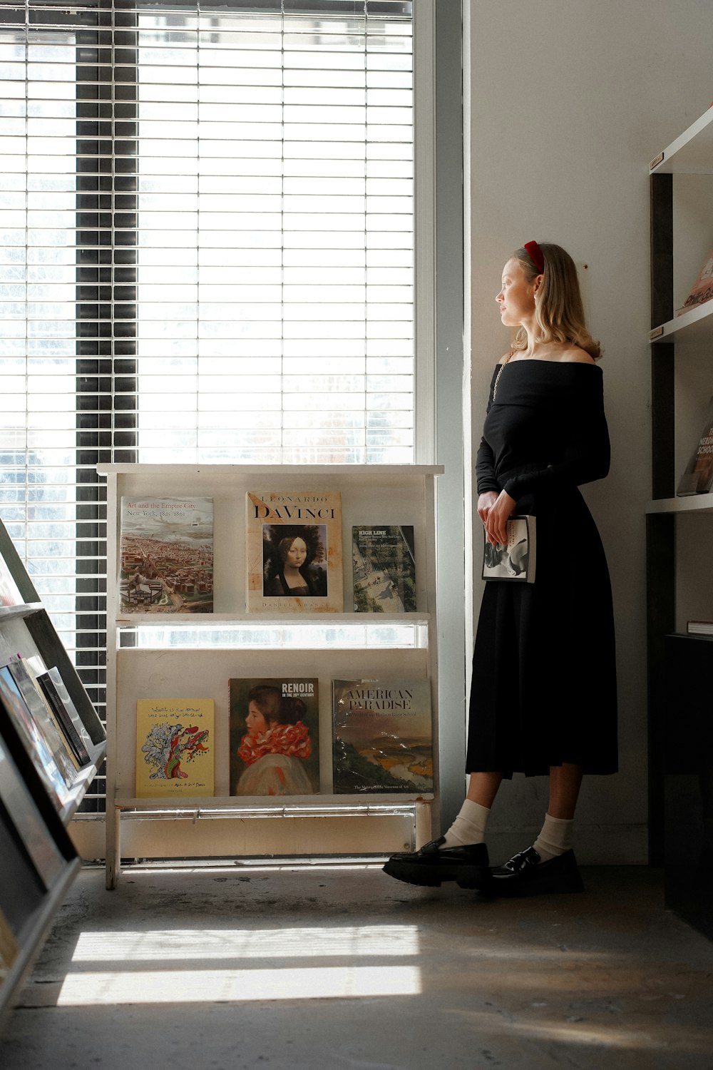 a woman standing in front of a book shelf