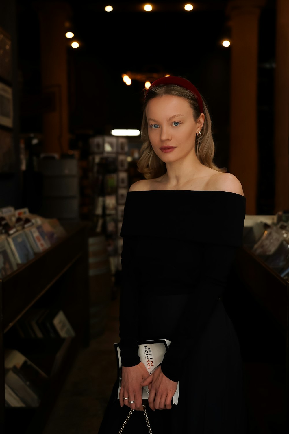 a woman standing in a store holding a purse