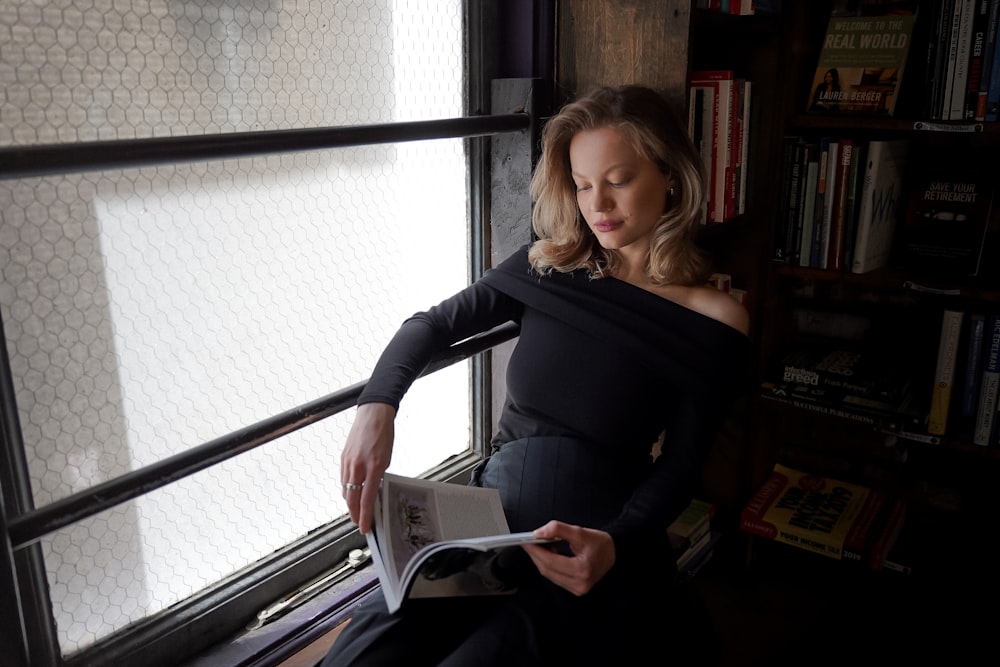 a woman sitting in a chair reading a book