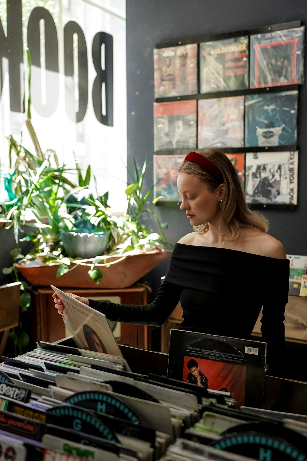 a woman sitting at a table reading a magazine