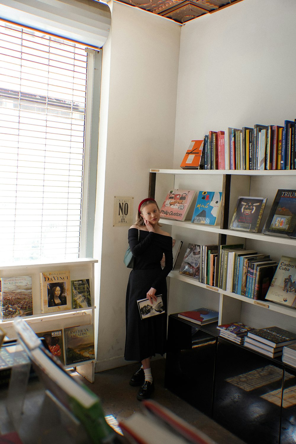 a woman standing in front of a bookshelf