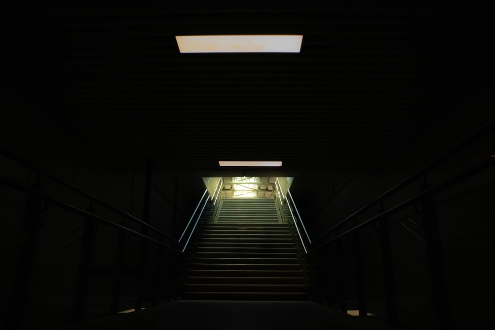 a stairway leading to a light at the end of a tunnel