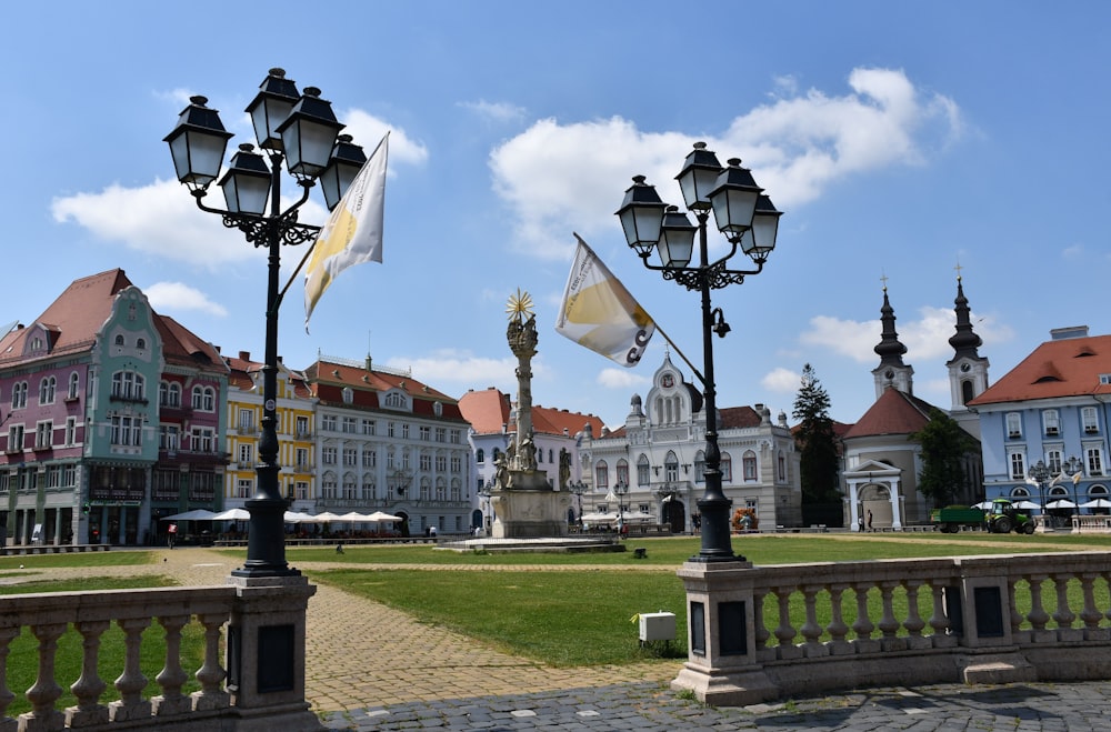 a row of street lights sitting next to a lush green park