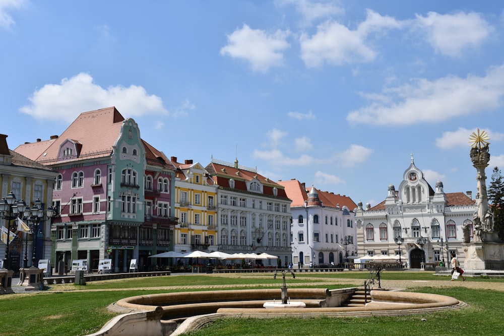 a group of buildings sitting next to each other on a lush green field