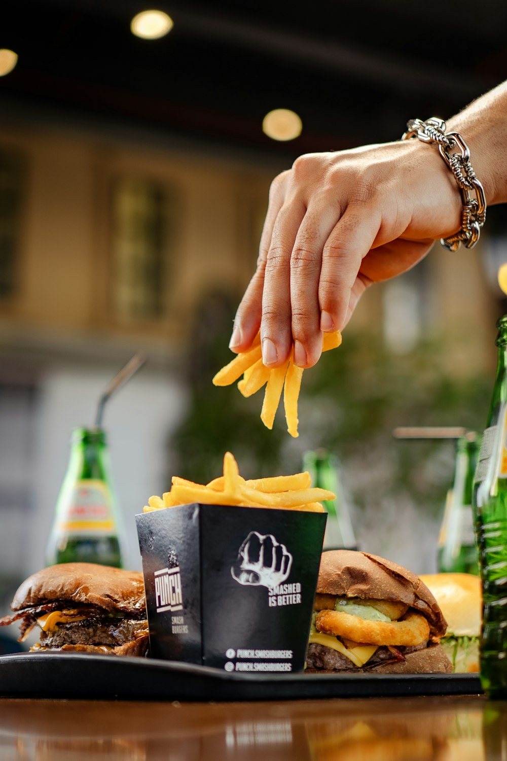 a person grabbing french fries from a tray