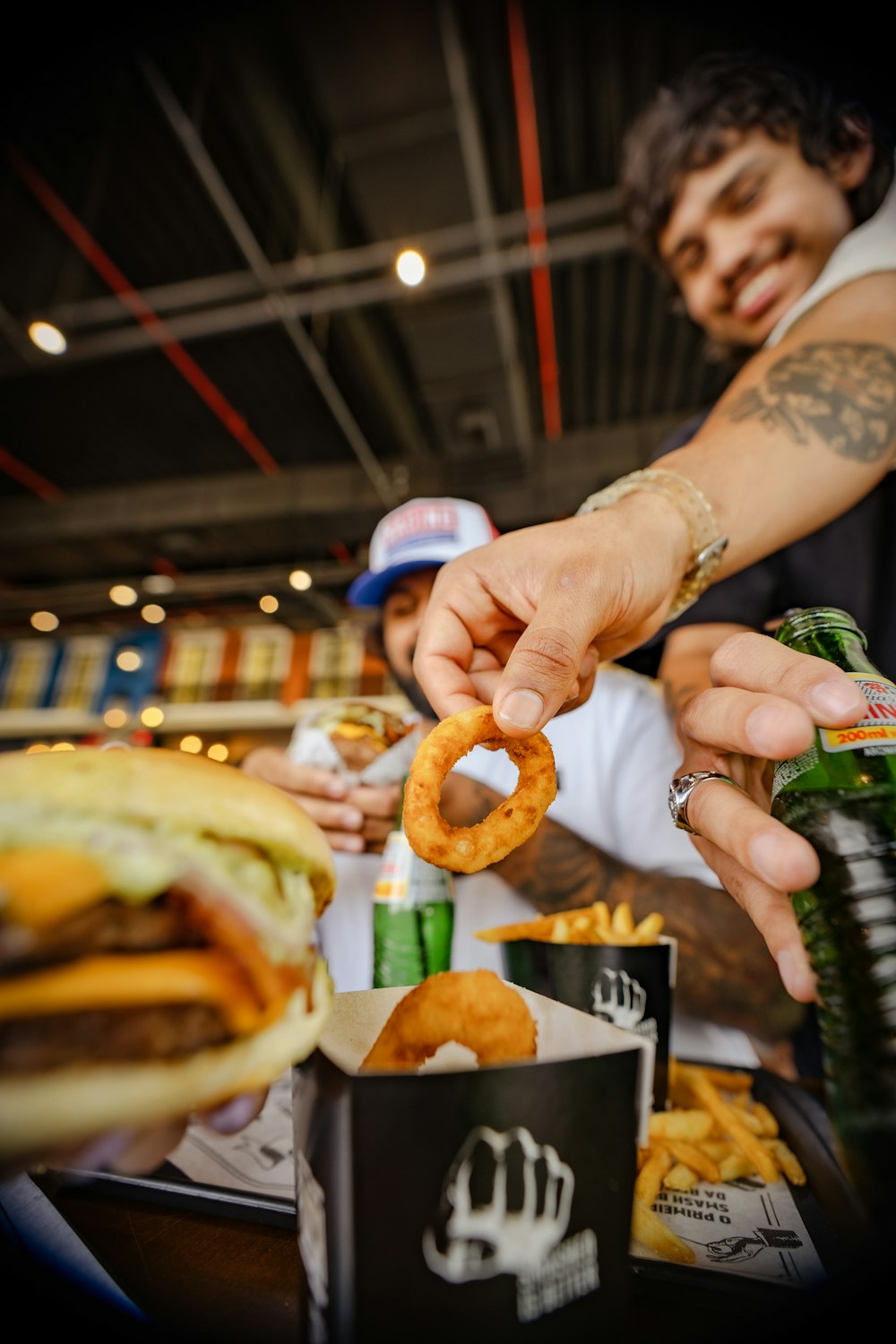 a man is putting a ring on a hamburger