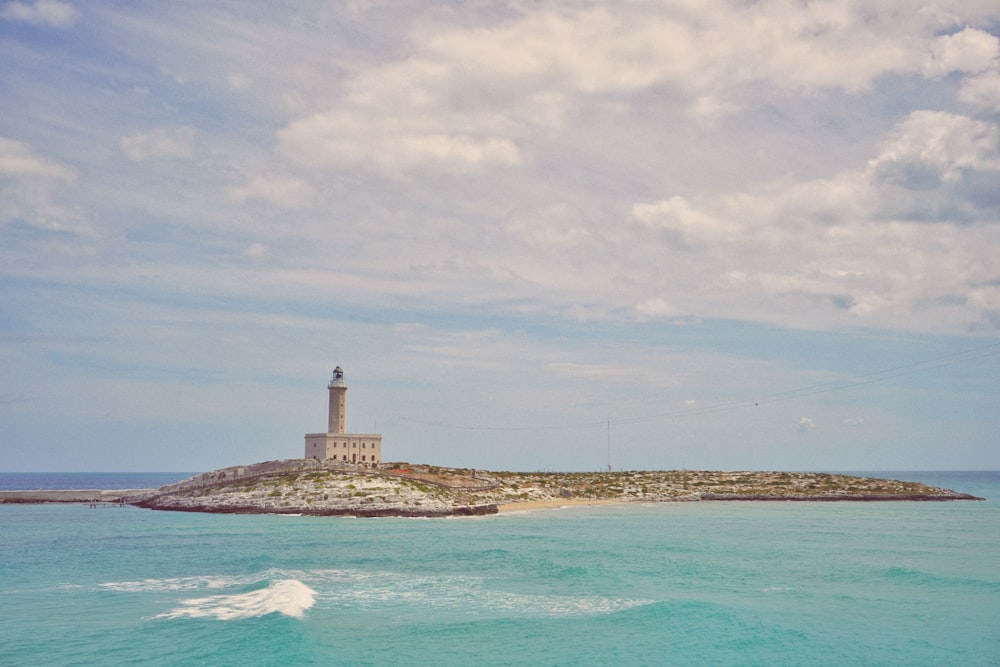 a lighthouse on a small island in the middle of the ocean