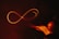 A glowing, red infinity symbol is drawn in mid-air against a dark background. It appears to be created by a light painting technique, with trails of light forming the continuous loop. On the right, there is a blurred trace of a hand motion, suggesting the movement that created the shape.
