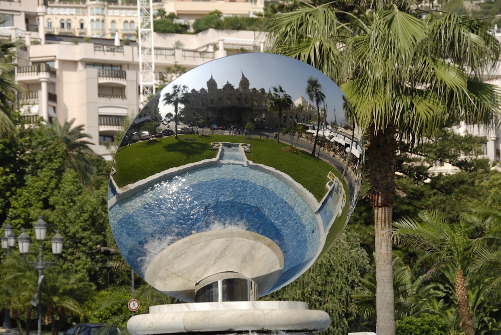 a large mirror reflecting a park with palm trees