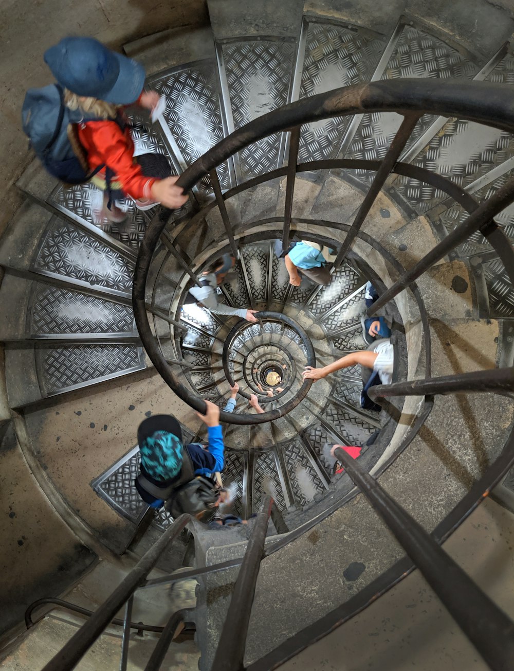 a group of people climbing up a spiral staircase