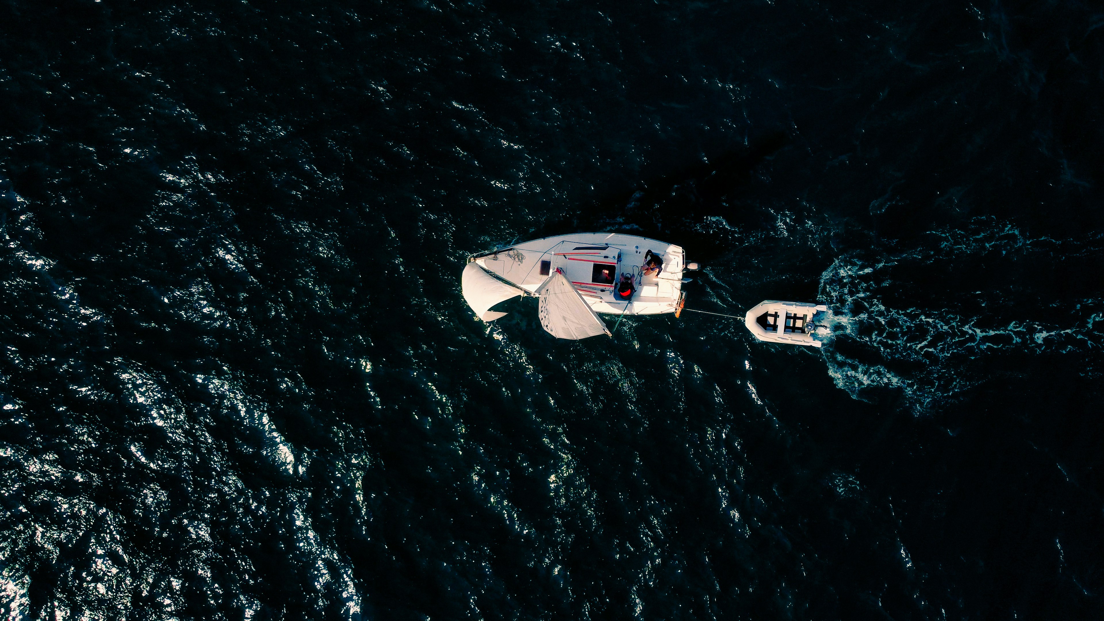 a small white boat floating on top of a body of water